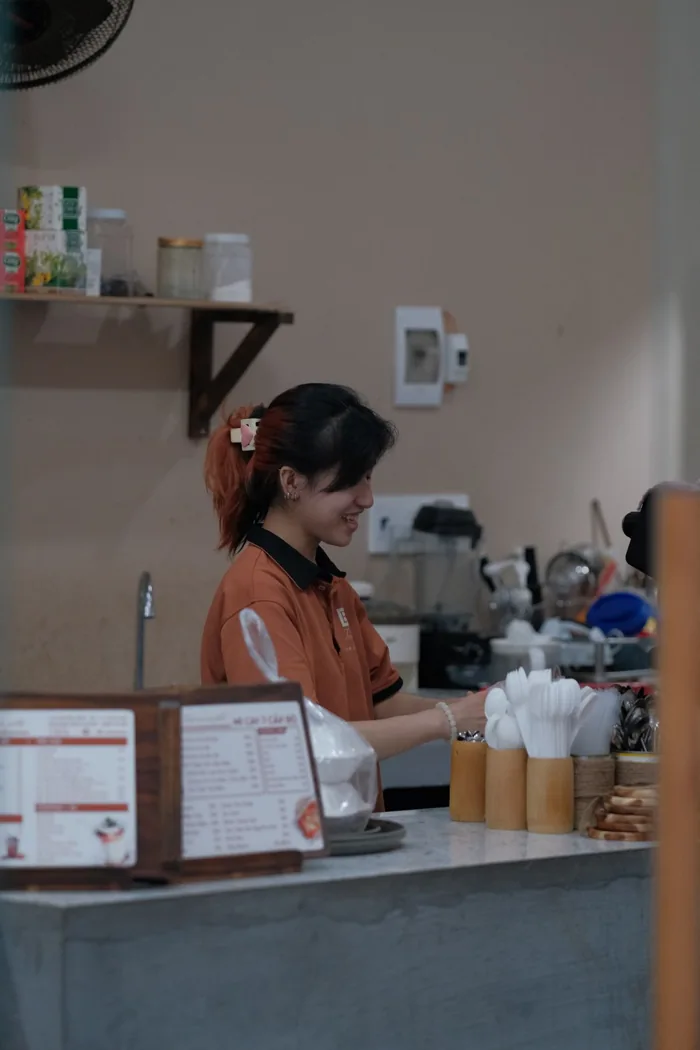 ผู้ให้บริการร้านกาแฟกำลังดูแลเคาน์เตอร์ ภาพถ่ายโดย Pew Nguyen